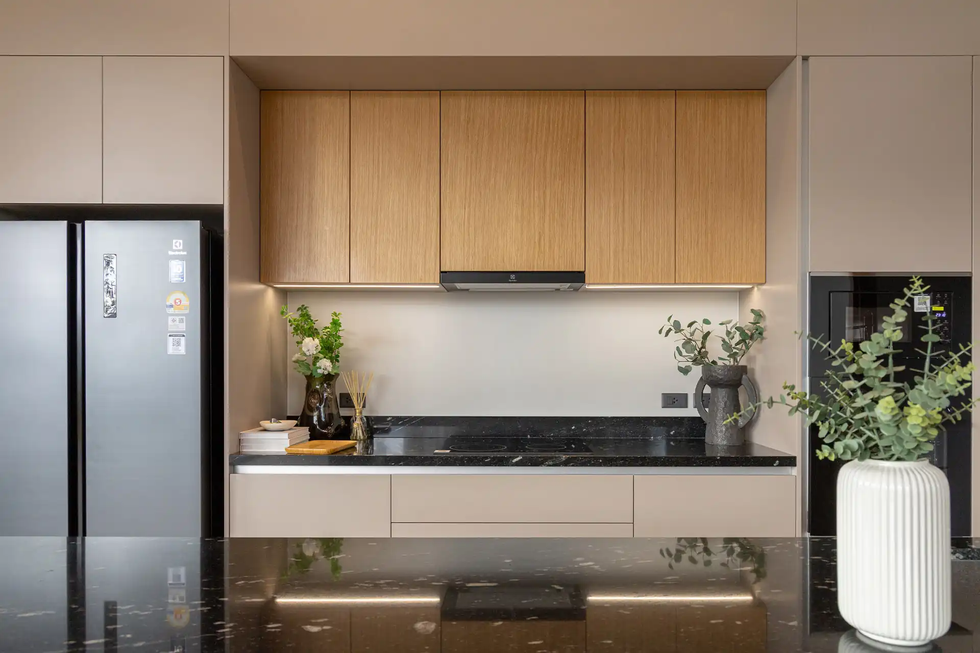 Botanica Four Season Thalang modern kitchen with wood cabinets and black countertop