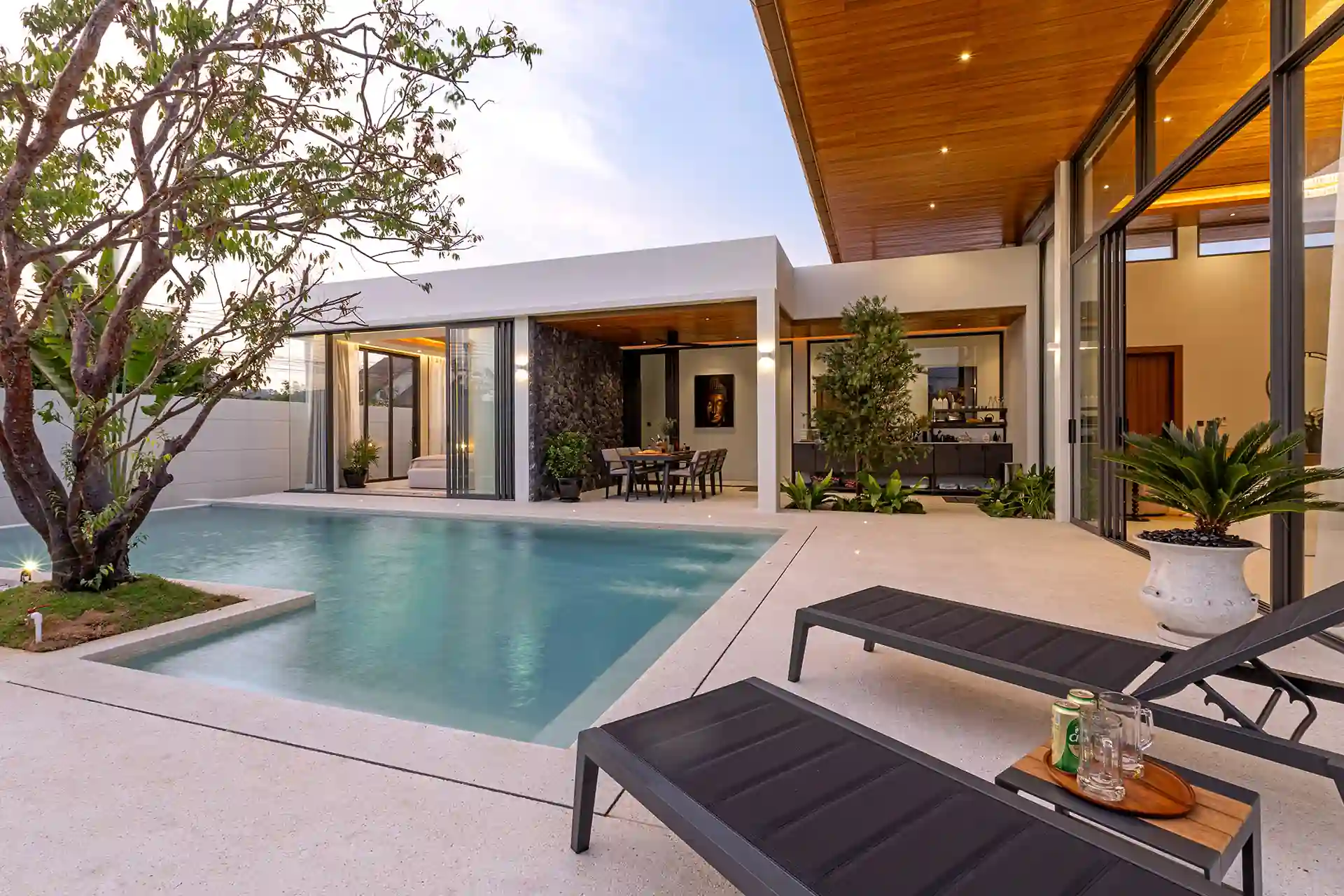 Mouana Cherng Talay pool deck with loungers, tree and outdoor dining