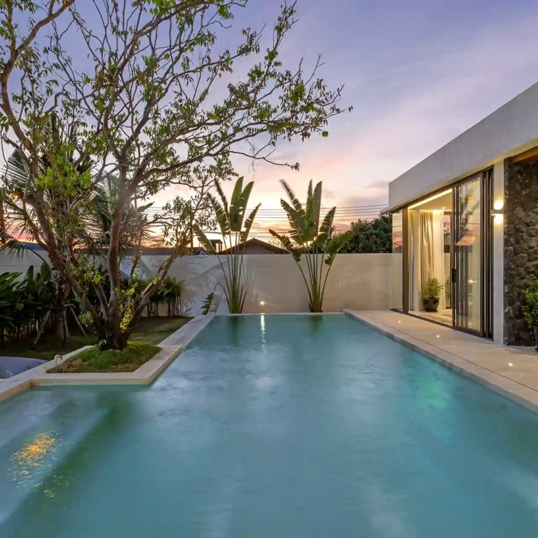 Mouana Cherng Talay sunset pool with stone wall and tropical foliage