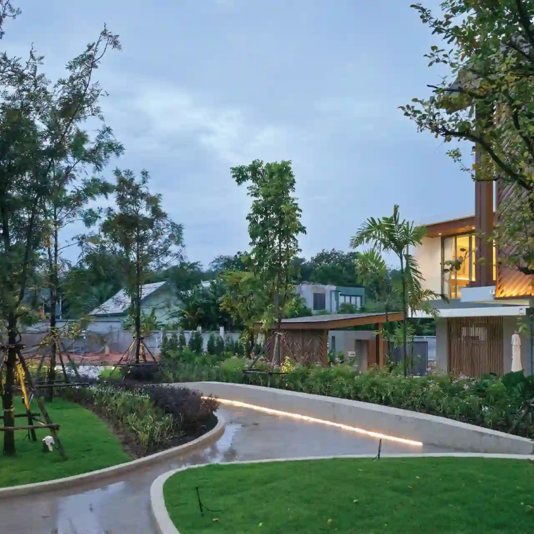Serene Raya Bangjo community park with trees, lawns and illuminated curved paths