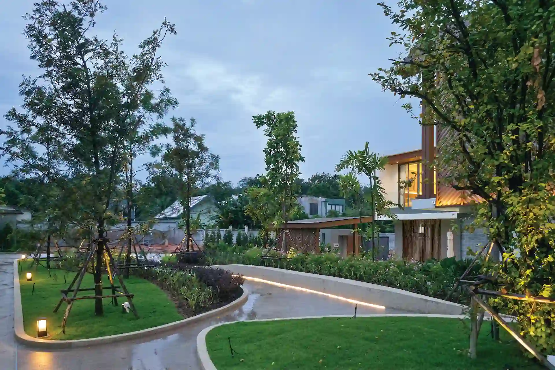 Serene Raya Bangjo community park with trees, lawns and illuminated curved paths