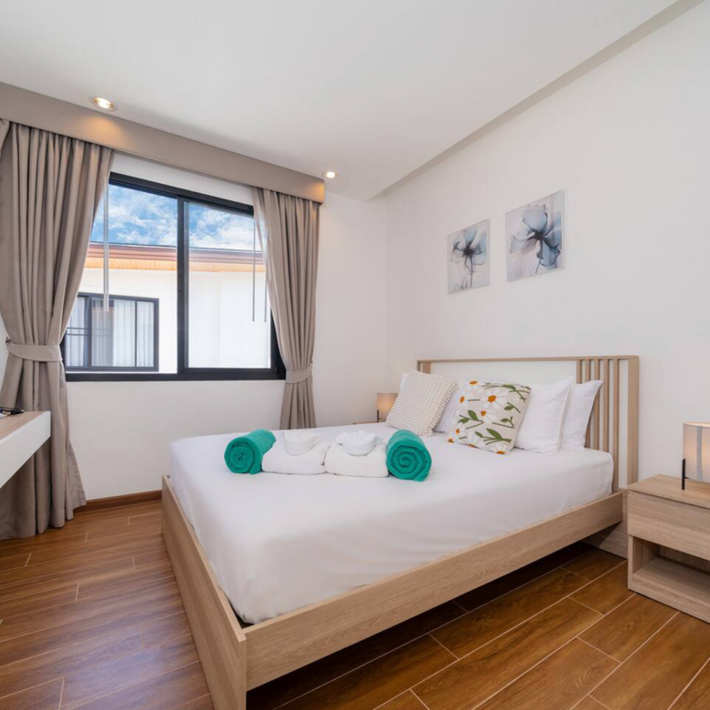 Goldena Twin Kamala guest bedroom with wall-mounted TV and curtains