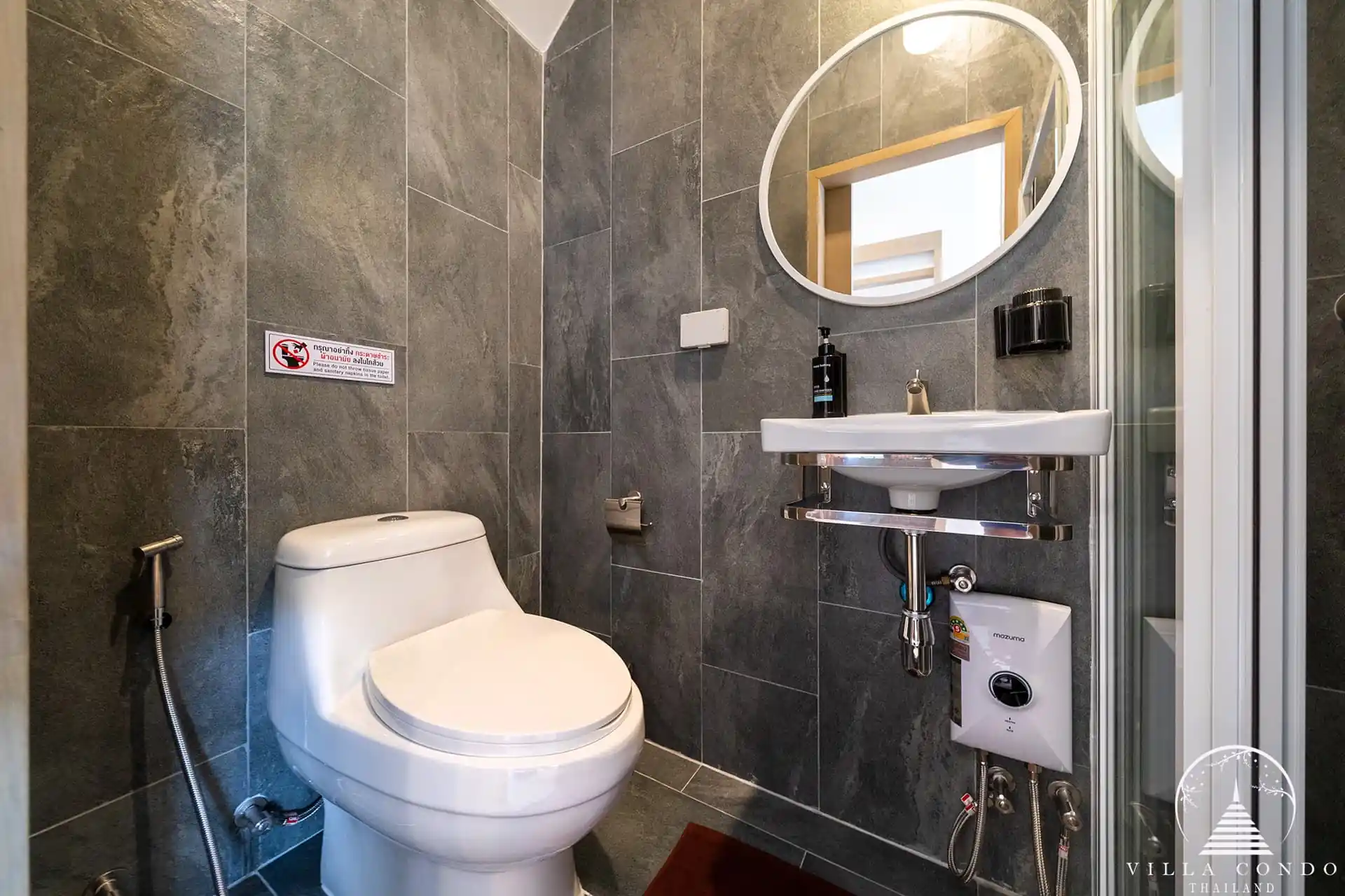 Goldena City Gems Kamala bathroom with toilet sink and dark tiles